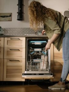 woman unloading dishwasher